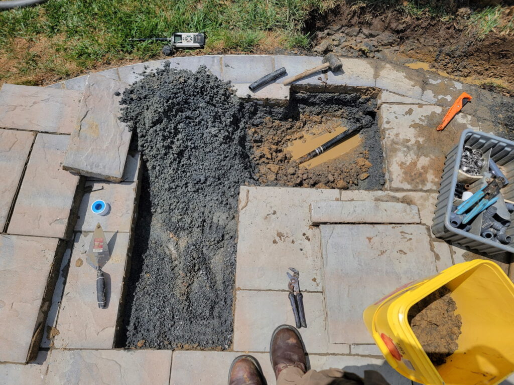 NJ irrigation repair under patio. Carefully removed pavers and earth to reveal leaking pipe.