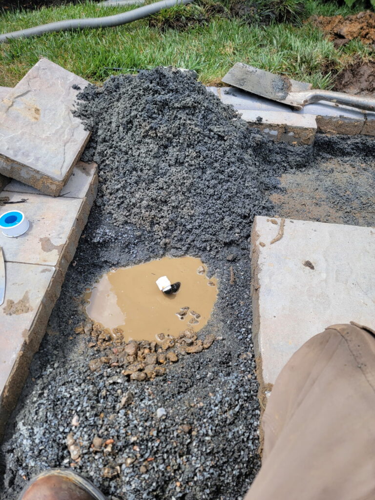 NJ irrigation repair under patio. Carefully removed pavers and earth to reveal leaking pipe.