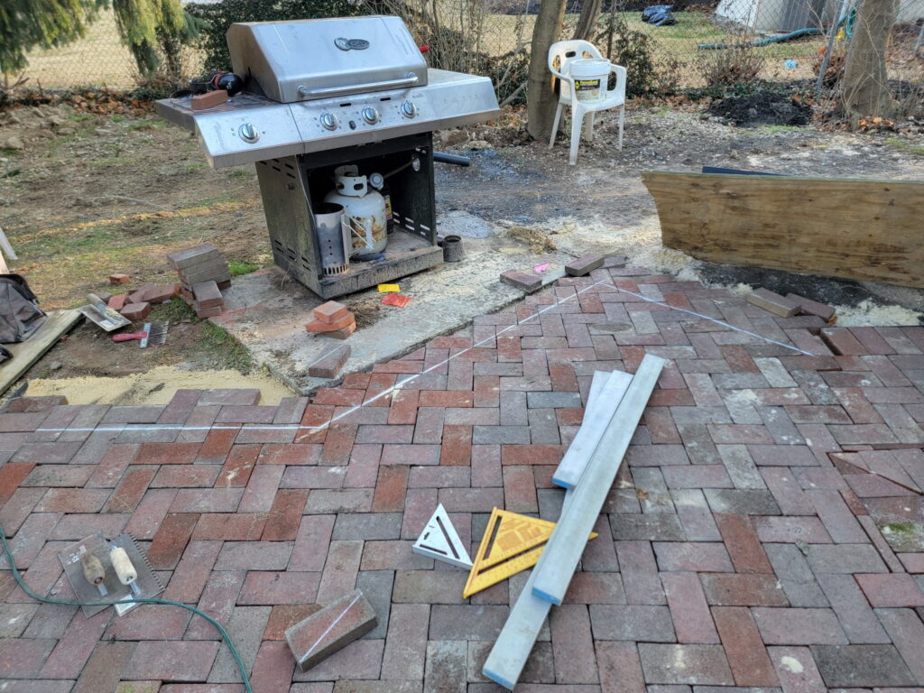 Yellow house paver bricks placed and marked for custom cut