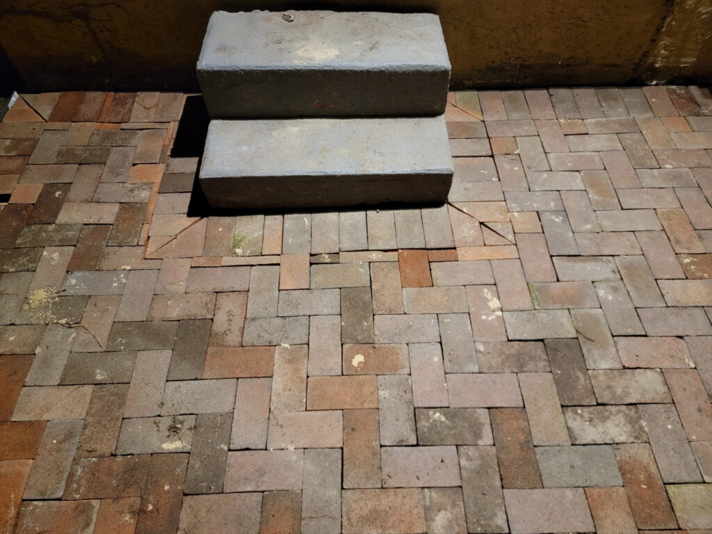 Yellow house paver installation detail around steps